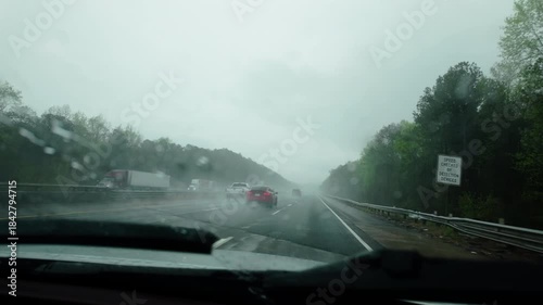 Driving car on the interstate highway road on heavy rainy weather. POV view from the front passenger seat