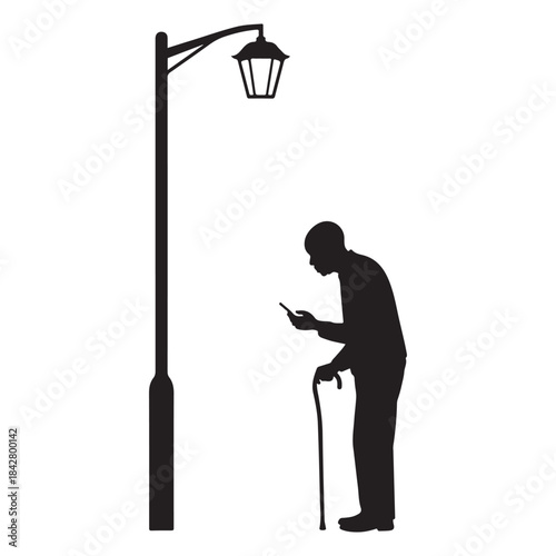 Silhouette of a man using phone under a street lamp