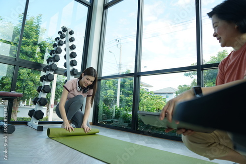 Wallpaper Mural Personal trainer guiding woman during workout session in gym Torontodigital.ca