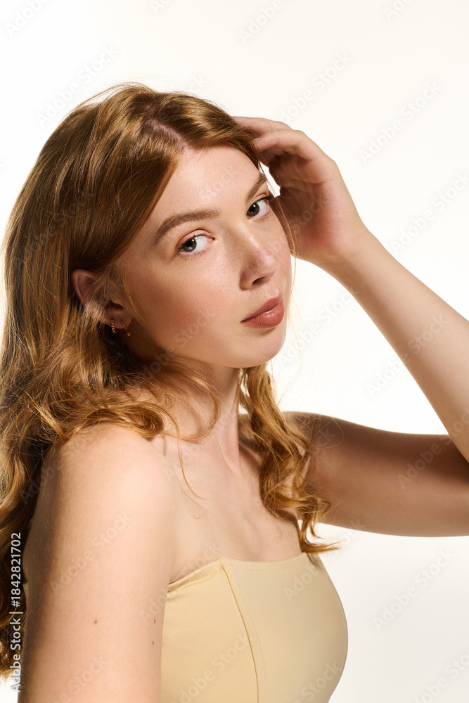 Obraz premium Natural beauty shines through in serene white studio with a lovely redhead
