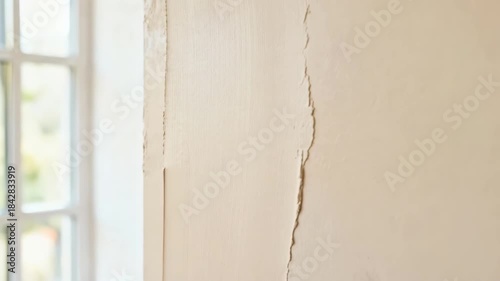 Closeup of a hand evenly applying matte ecofriendly paint on an interior wall highlighting sustainable home renovation with lowVOC nontoxic materials.