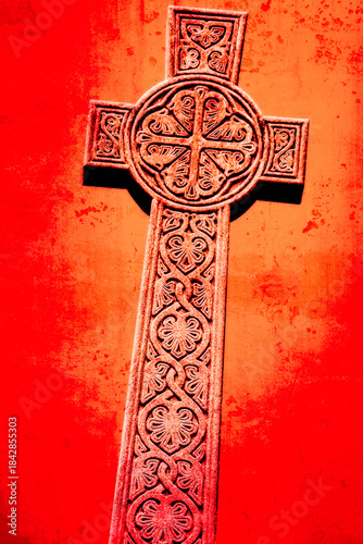 Celtic cross carved in stone on a red background