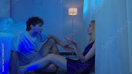 A couple talking and relaxes in their bedroom before bed on a night with a blue moon
