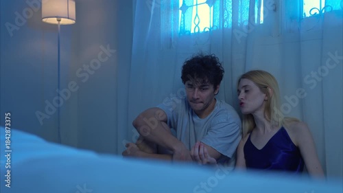 A couple talking and relaxes in their bedroom before bed on a night with a blue moon