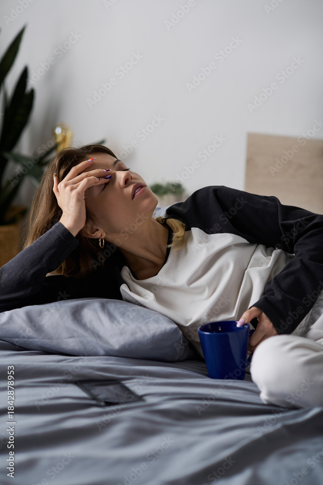 Obraz premium Young woman enjoying a lazy day in bed in her cozy apartment sanctuary