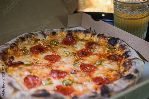 Close up photo of pepperoni pizza in a take away box at home wit dark cosy light 