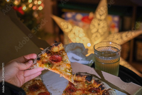 A slice of pepperoni pizza, take away food at home, Christmas decorations, amateur phone style photo 