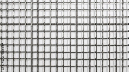 A close-up view of a metallic grid with uniform square openings and a textured surface pattern.