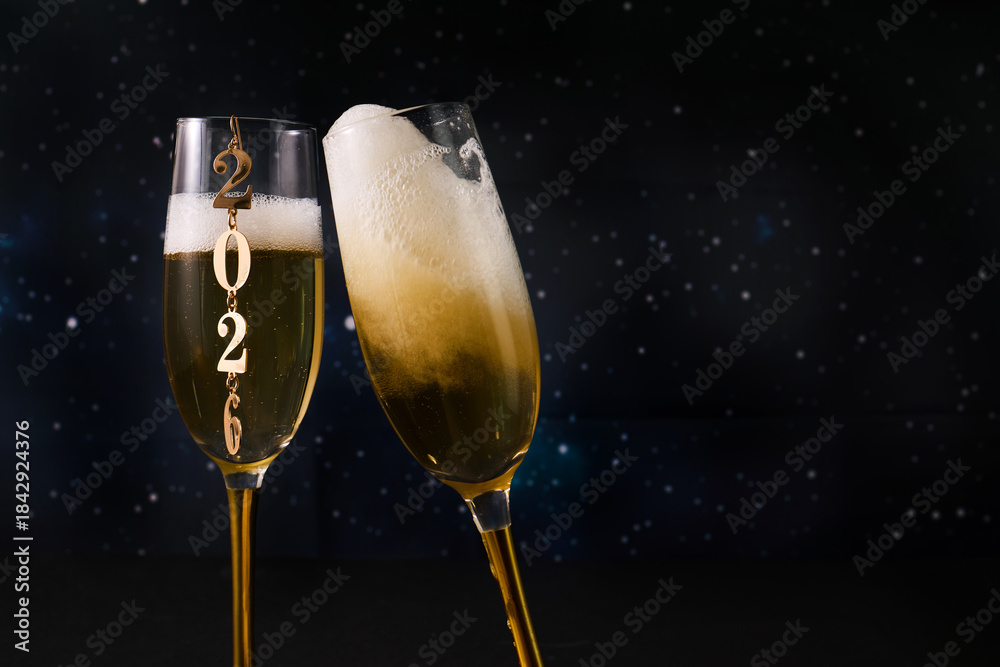 Obraz premium New Year Celebration. Two champagne glasses against a starry backdrop celebrating 2026.