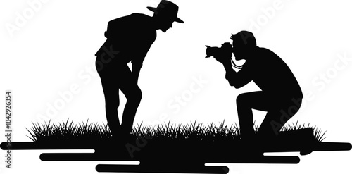 Silhouette of a photographer capturing a subject in a field