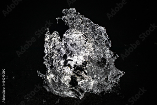 Intricate backlit ice formation glowing against a pitch black background