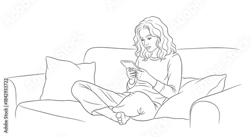Woman relaxing on a cozy sofa scrolling on her phone with legs folded and cushions around her in a calm home setting today.