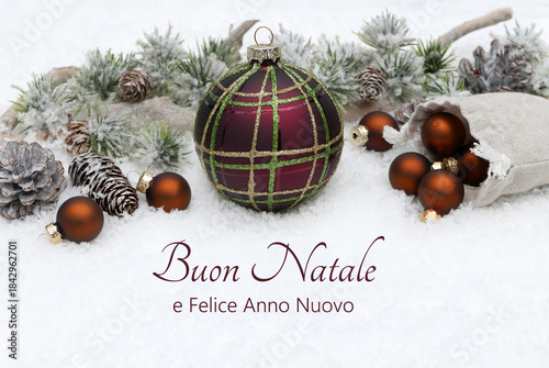 Biglietto di auguri di Natale in italiano: decorazione con palline di Natale e rami di abete nella neve. Buon Natale e felice anno nuovo.