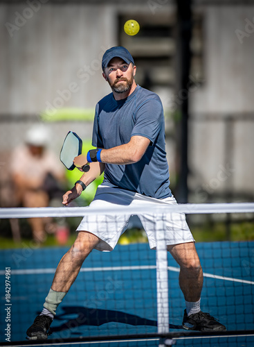 Male pickleball player about to hit backhand volley during tournament