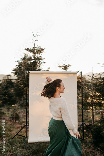 Dunkelhaarige Frau, 40+, vor einem beigen Hintergrund in der Natur