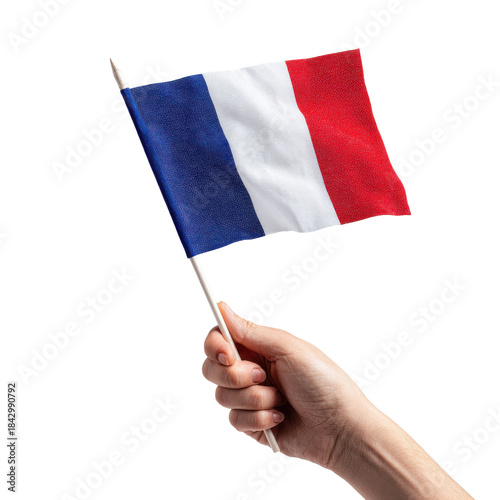 Hand holding a small french flag on a stick against a black background