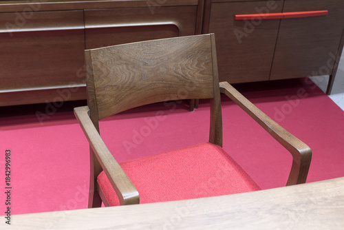 Wooden desk and chair with red seat on the red floor in the living room, close-up