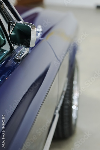 Side mirror and window close-up details of a blue vintage American Car. Vertical classic vehicle photo with copy space.