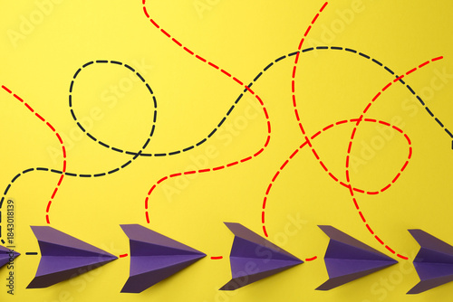 Foto Paper planes with dotted lines as air route track on yellow background
