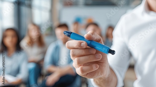 Presenter's hand holds a blue marker during a business presentation