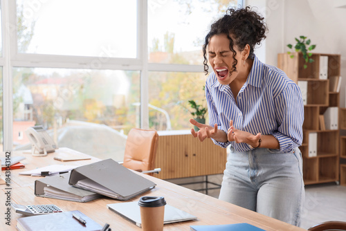 Tableau sur toile Angry African-American businesswoman shouting in office