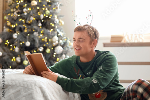 Young man reading book in b...