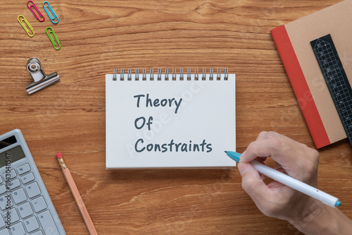 There is notebook with the word Theory Of Constraints. It is as an eye-catching image.