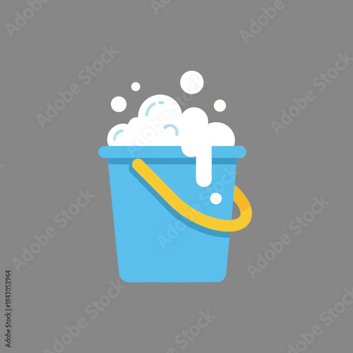 A blue bucket is filled with white soap bubbles and has a yellow handle.