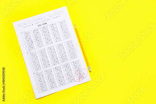 Pencil and answer sheet form of school test with results on yellow background