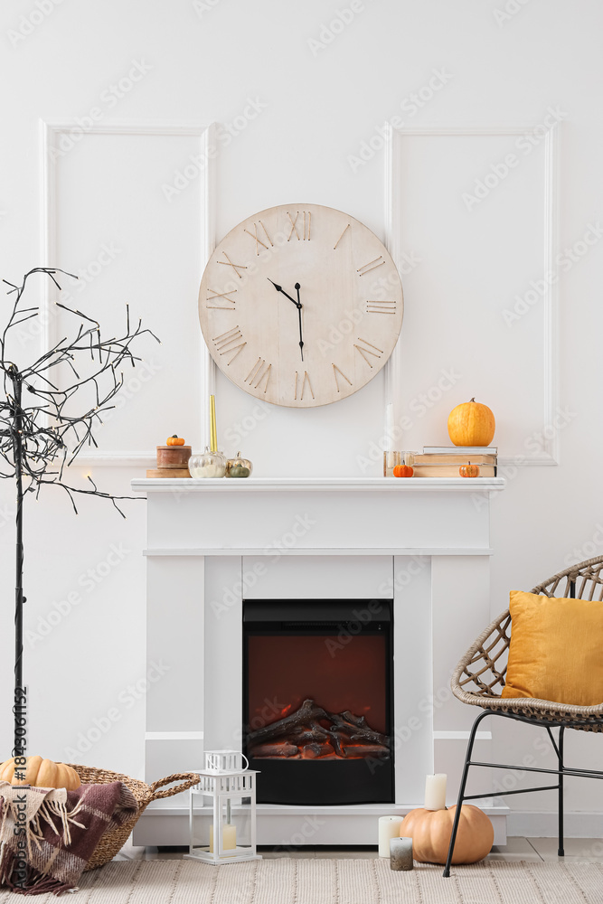 Obraz premium Interior of light living room with white fireplace, cozy armchair, modern lamp and clock
