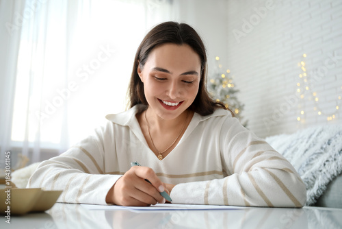 Beautiful young woman writi...