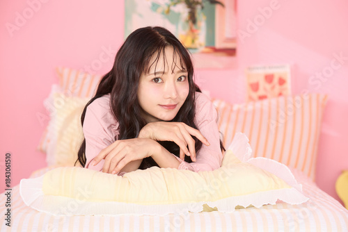 カラフルなベッドレームでリラックスする若い女性のかわいいポートレート