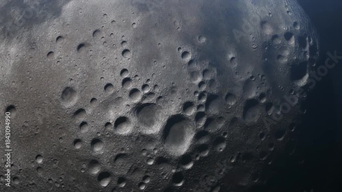 Detailed close-up view of the lunar surface showcasing numerous impact craters and a rugged, rocky texture against a dark space background.