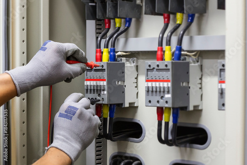 Electrical engineer checking the operation of electrical control cabinet, maintenance concept.	