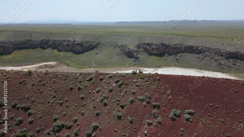 Tourists exploring the red surface of Lake Meke volcano crater rim in Konya