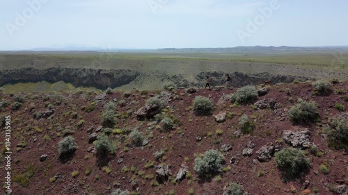 Tourists exploring the red surface of Lake Meke volcano crater rim in Konya