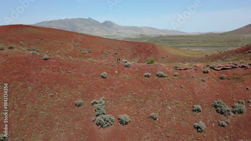 Tourists exploring the red surface of Lake Meke volcano crater rim in Konya