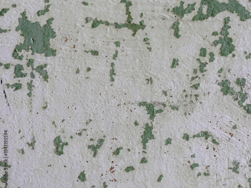 Peeling paint on the wall. Old concrete wall with cracked flaking paint. Weathered rough painted surface with patterns of cracks and peeling. Texture for background and design. Closeup