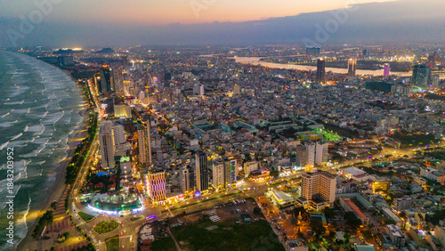 Aerial drone panorama of Da Nang city center split by the Han River. Massive urban skyline featuring iconic bridges connecting the modern metropolis in Vietnam