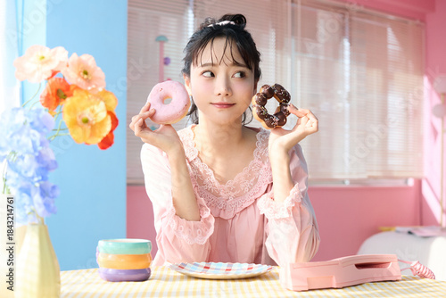 カラフルな部屋でドーナツを食べるかわいい女性のポートレート