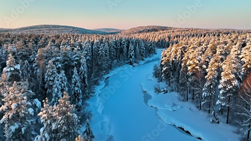 Aerial View of Snow-Covered Forest and Frozen River in Winter.