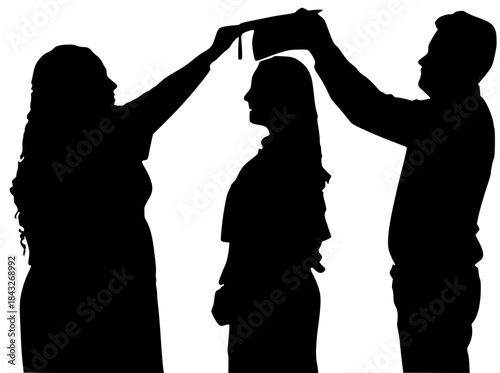 Black silhouette of a student graduate being celebrated by two parents who hold the cap above their head.