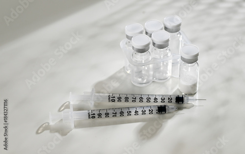 Close up of Empty Glass Vials with One Filled with Lyophilized Substance 