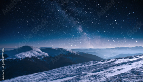 snow-covered mountains under a starry night sky with visible milky way.