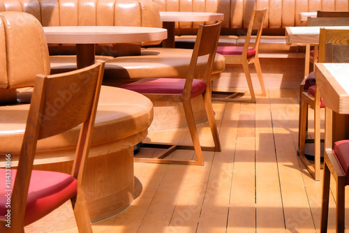 Wooden chairs and tables in a row in the interior of a restaurant