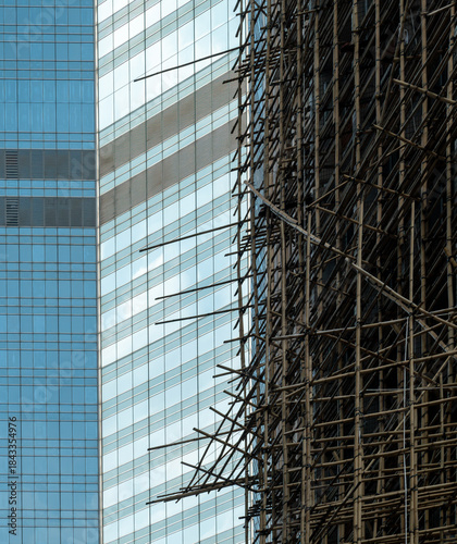 Photography Traditional Bamboo Scaffolding Against Modern Glass Skyscraper Facade in Hong Ko