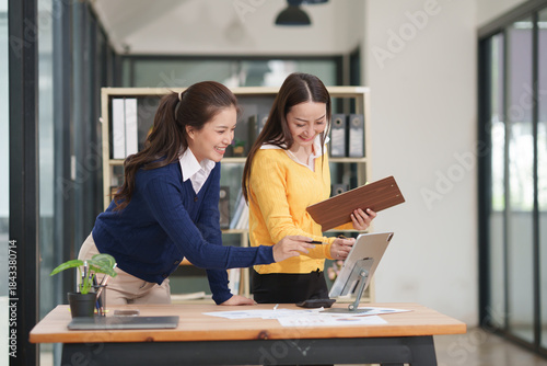 Asian businesswoman sitting at work using laptop talking and consulting in office