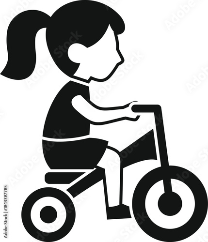 Side view silhouette of a little girl riding a tricycle