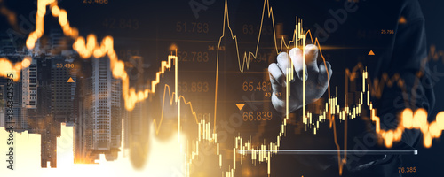 Businessman analyzing rising forex and crypto market charts with golden graphs over modern city background concept in New York City at sunset.