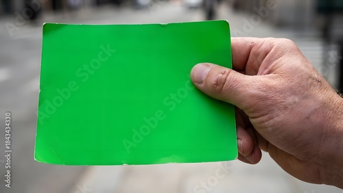 Person Holding Bright Green Card in Hand.
